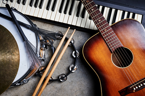 a group of musical instruments including a guitar, drum, and keyboard